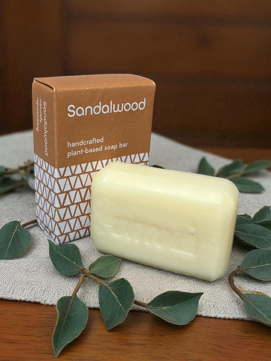 Sandalwood soap on a wooden table with a linen cloth and eucalyptus