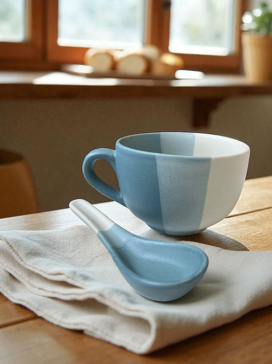 blue striped jumbo mug with matching spoon on a linen cloth with bread in the background