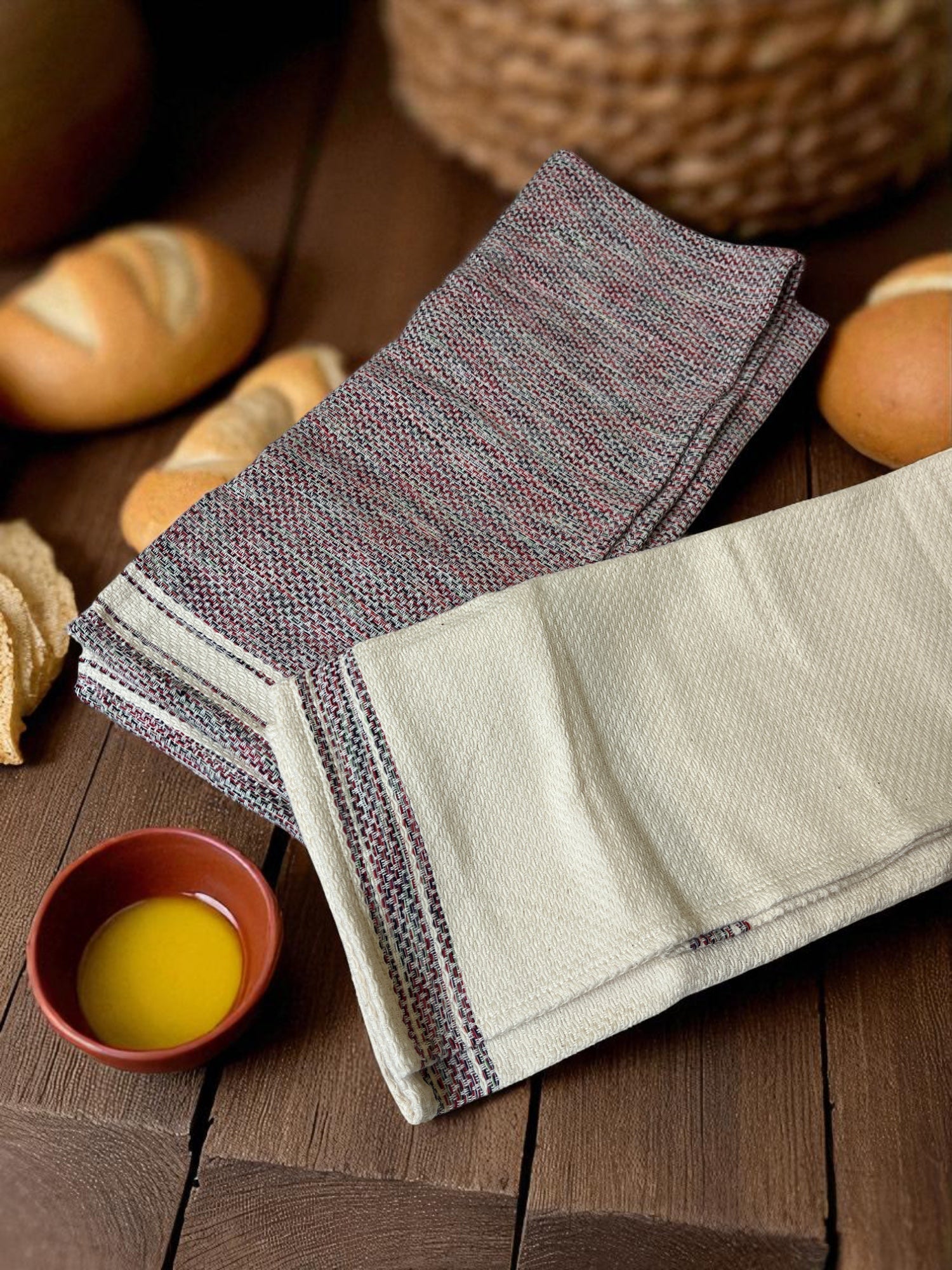 folded Egyptian hand towels on a wooden table with bread and a dish of butter