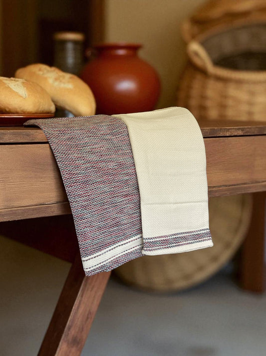two folded Egyptian hand towels draping off a table with bread and pottery