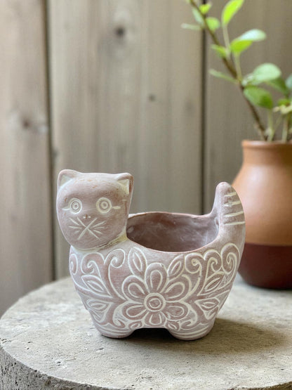 Ceramic cat-shaped planter with intricate patterns on a wooden surface.