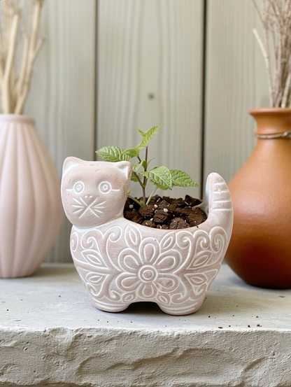 Cat-shaped ceramic planter with a small plant on a surface with other decorative vases.